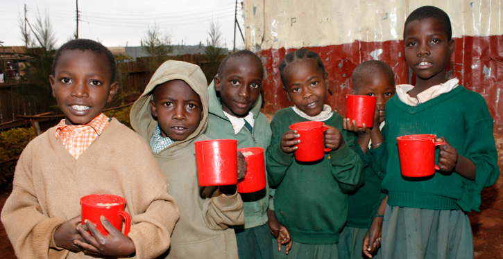 Group of children hold red cups. 